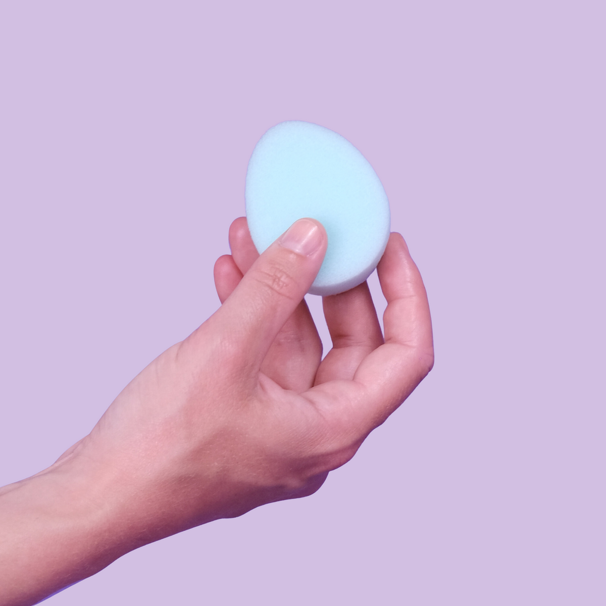 A hand holding blue tampon without a string
