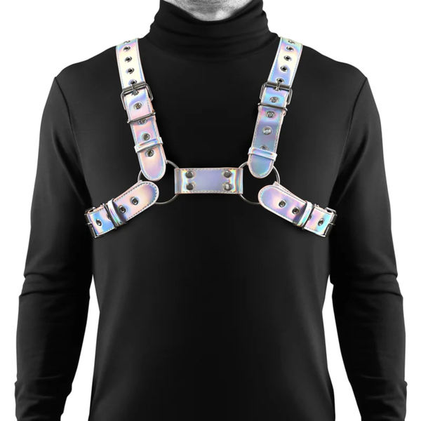 Direct studio front view of a model wearing the adjustable iridescent vinyl chest harness with metal O-ring connectors and buckle straps over a black turtleneck shirt.