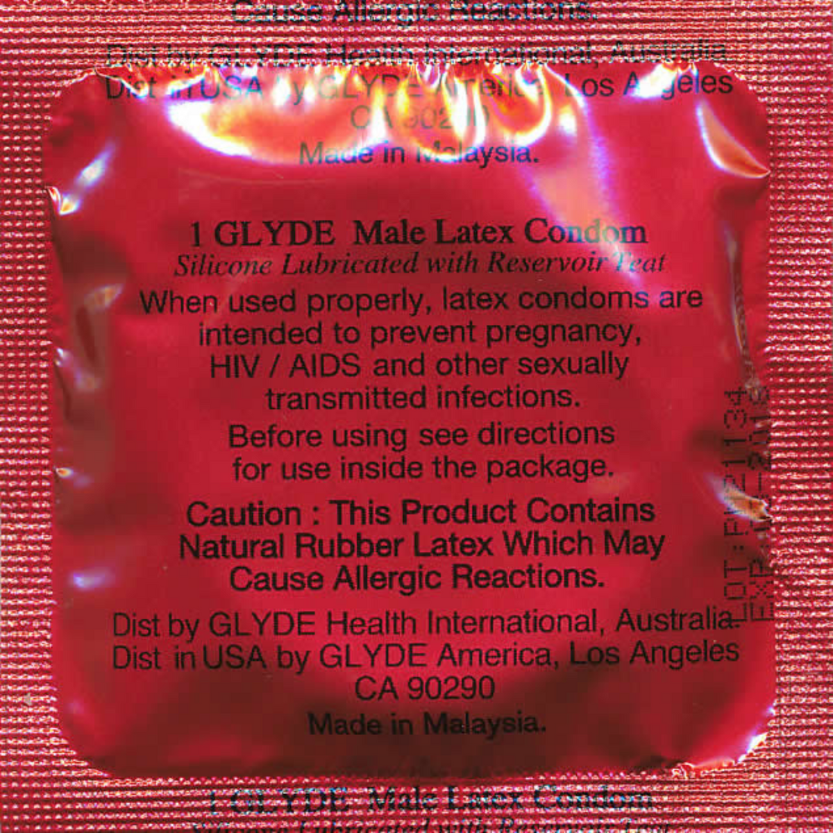 A close-up of the back of a single Glyde Slimfit condom wrapper. The wrapper is red. The text on the wrapper includes product information and warnings: "1 GLYDE Male Latex Condom Silicone Lubricated with Reservoir Tip".