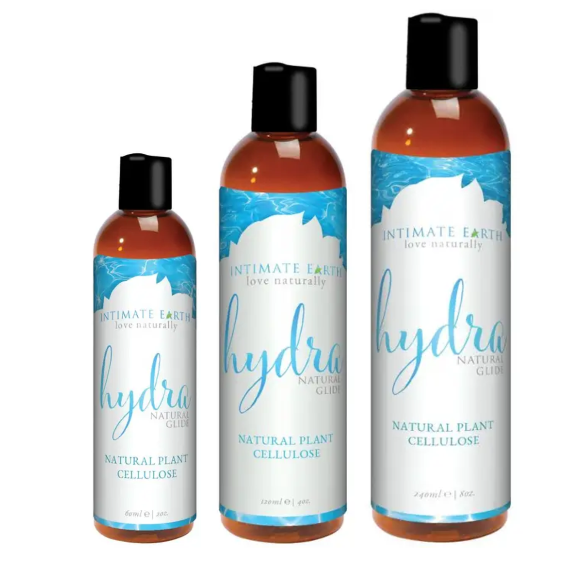 Size comparison view showing three amber bottles of Intimate Earth Hydra natural plant cellulose glide standing side by side in 60 ml (2 fl oz), 120 ml (4 fl oz), and 240 ml (8 fl oz) capacities. Hauptbild