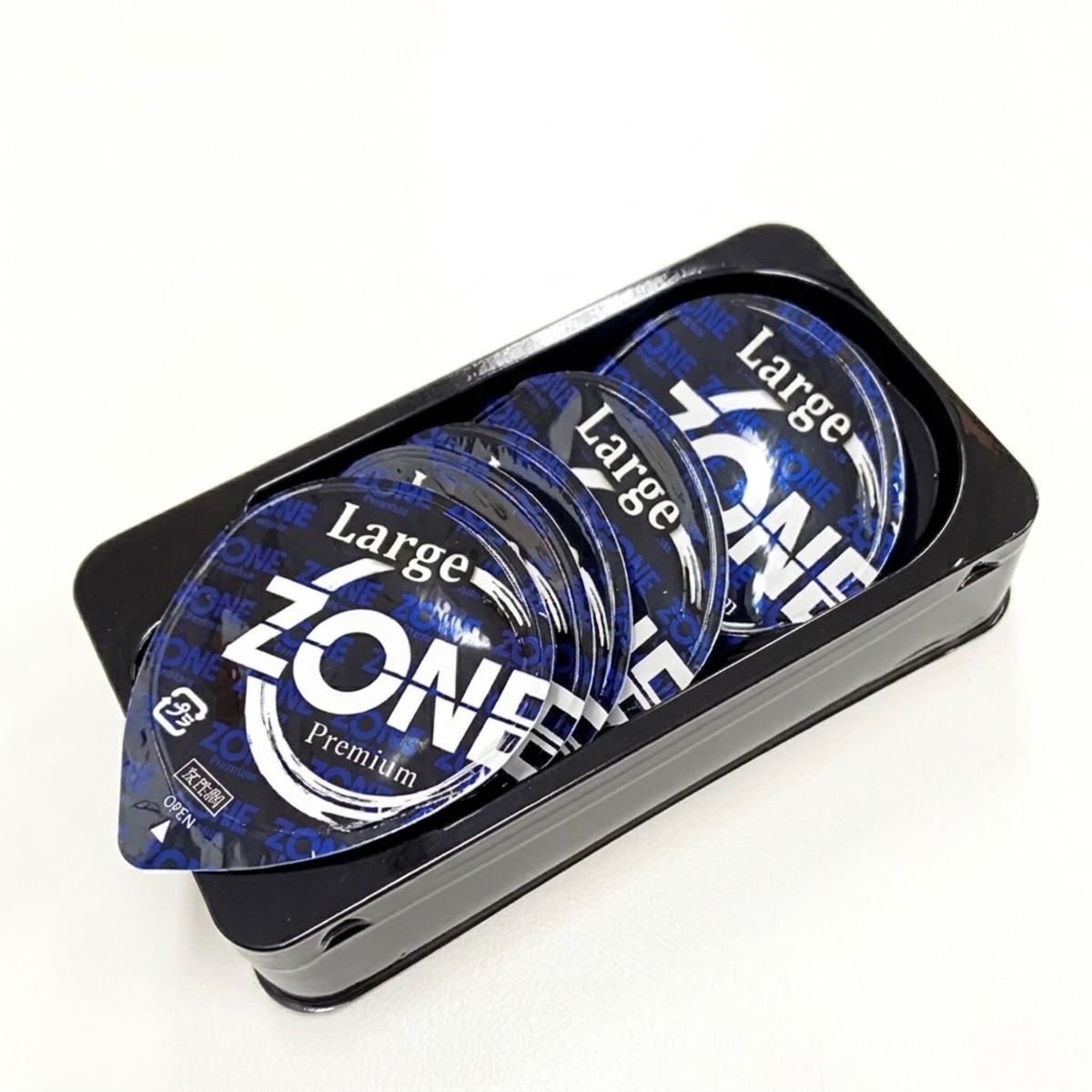 Open packaging shot showing five individual blue-and-black rigid blister pack pods labeled "Large ZONE Premium" arranged inside a black tray container.