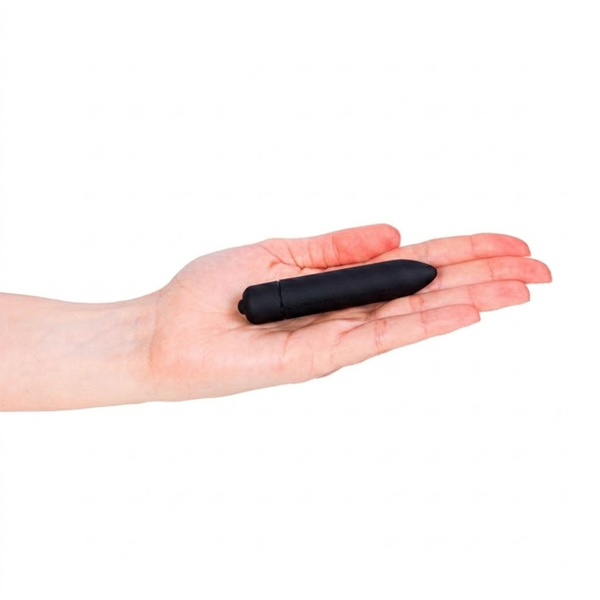 Scale perspective photo showing the small matte black bullet vibrator lying flat across an open palm.