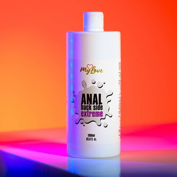 Front view of the 1000 ml MyLove Anal Back Side Extreme bottle standing on a reflective surface against a bold orange and pink gradient backdrop.
