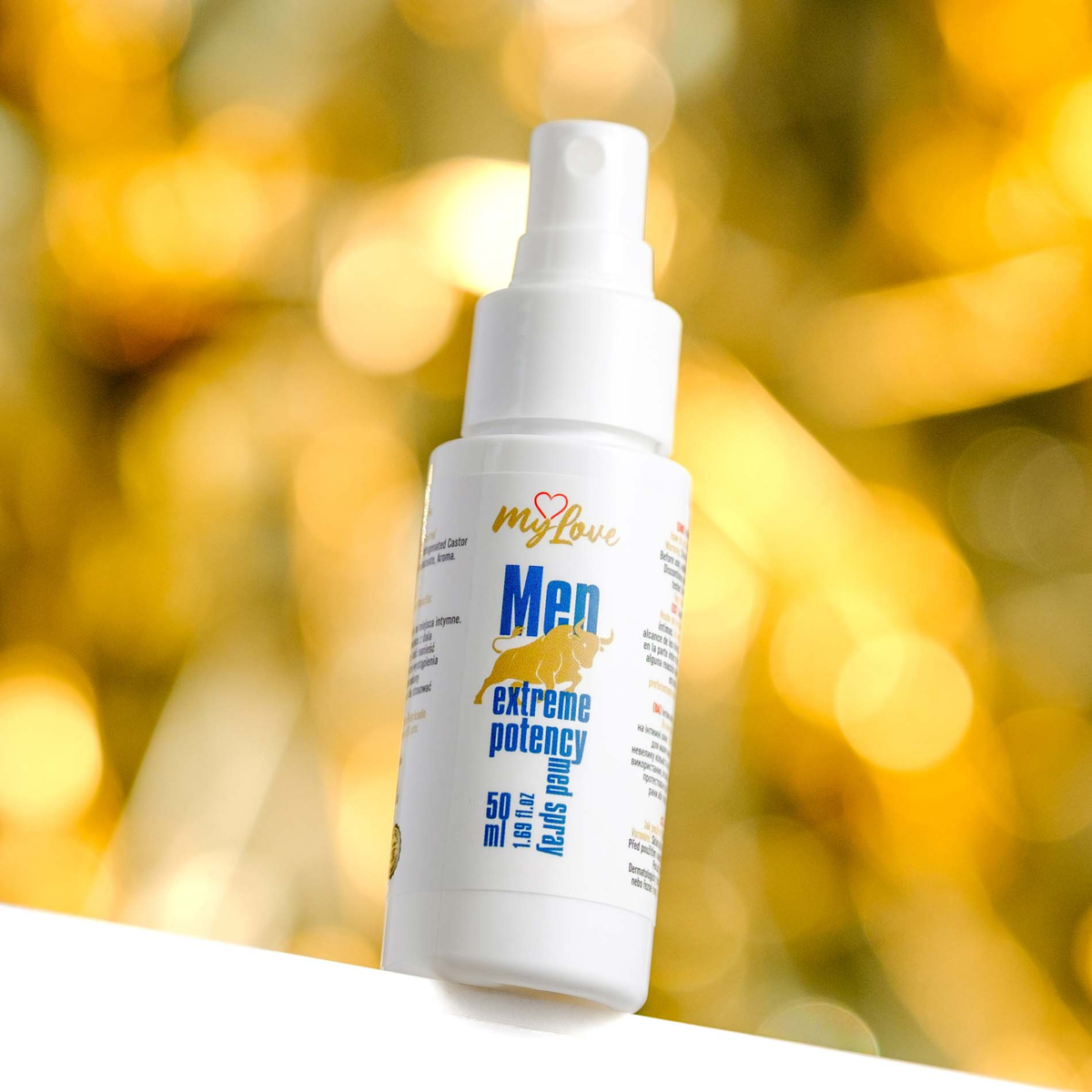 White spray bottle labeled 'Men extreme potency' against a blurred yellow background