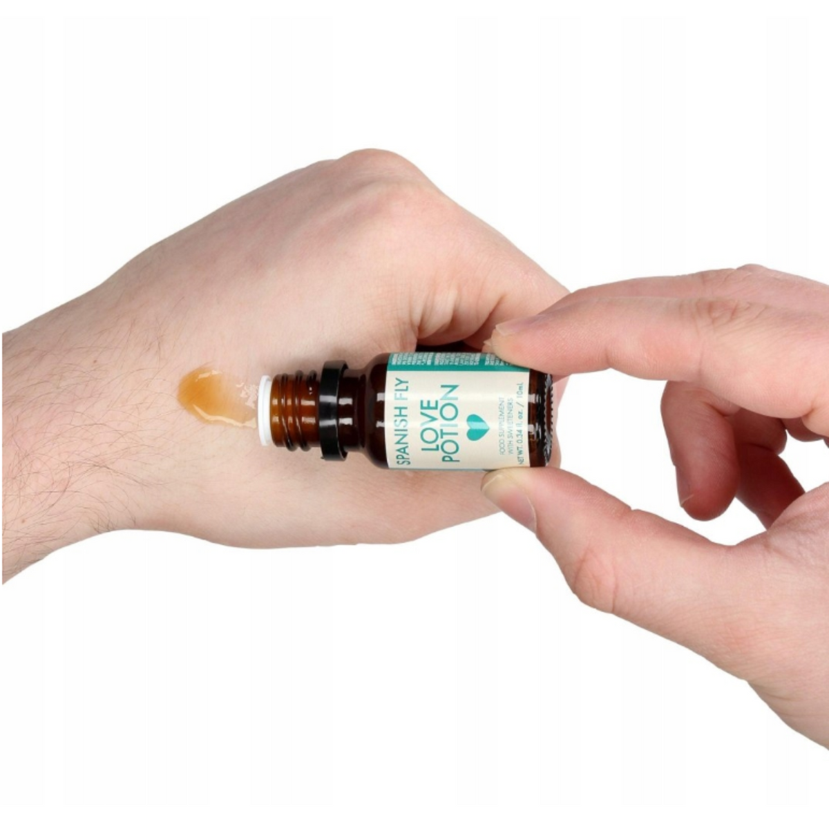 An image of a person's hand holding a small, brown dropper bottle labeled "Spanish Fly Love Potion." A drop of the amber-colored liquid is being dispensed onto the back of the hand.