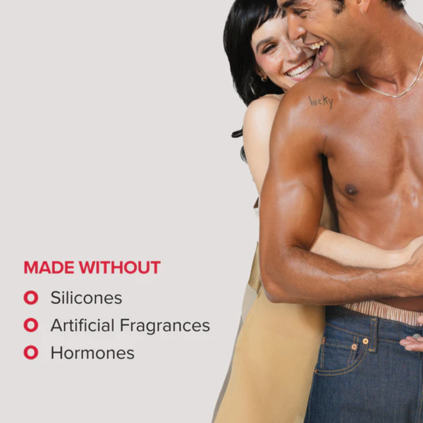 A cheerful couple hugging and smiling against a light grey background. Red bullet points on the left indicate the product is "MADE WITHOUT" silicones, artificial fragrances, or hormones.