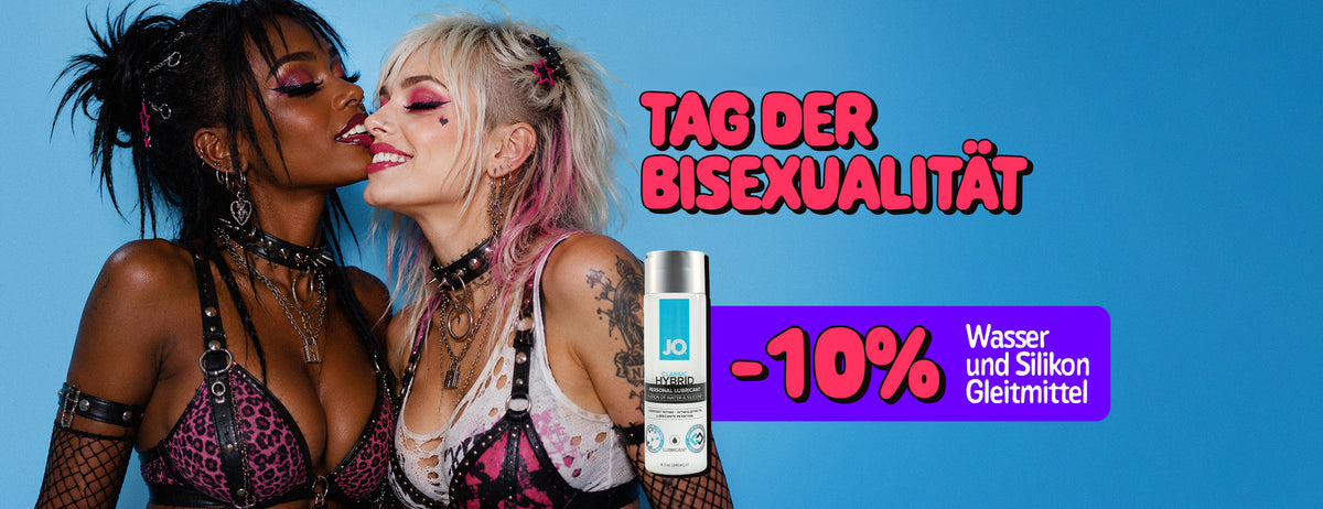 Promotional poster for Bisexuality Day. Two women in colorful alternative-style outfits and makeup pose closely together against a blue background, smiling with their faces touching. A purple promotional banner advertises “-10% Water & Silicone Lubes”, alongside an image of a personal lubricant bottle.