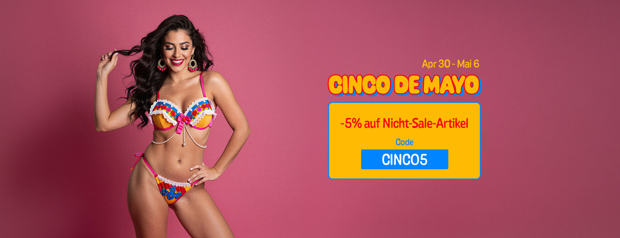 An advertisement for a Cinco de Mayo sale featuring a smiling woman with long, dark wavy hair against a solid pink background. She is wearing colorful, festive lingerie with white lace trim and large pink and gold hoop earrings. Overlaid on the image is text that reads 